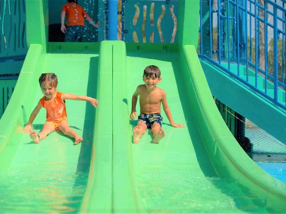 A couple of kids on a waterslide at LAKEWOOD CAMPING RESORT