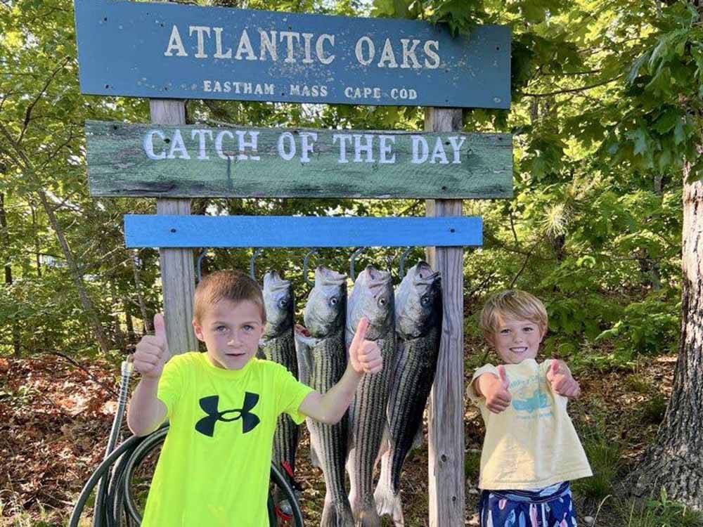 Kids standing in front of a catch of the day sign at ATLANTIC OAKS