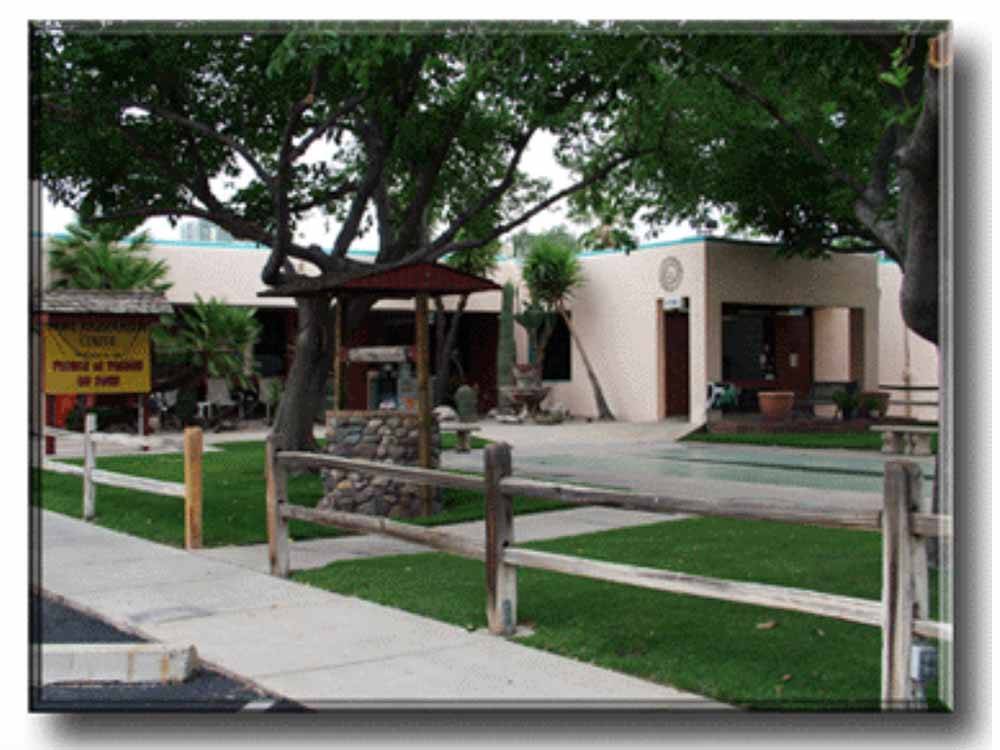 Grassy area with trees and wishing well at PRINCE OF TUCSON RV PARK