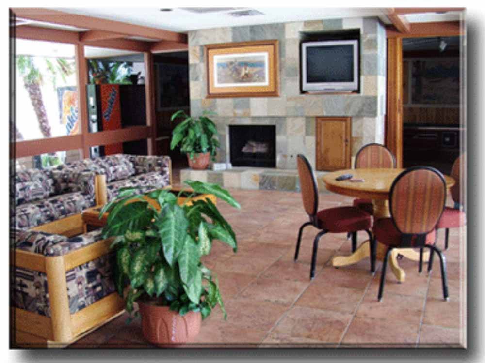 Indoor seating with couches, table and chairs and fireplace  at PRINCE OF TUCSON RV PARK