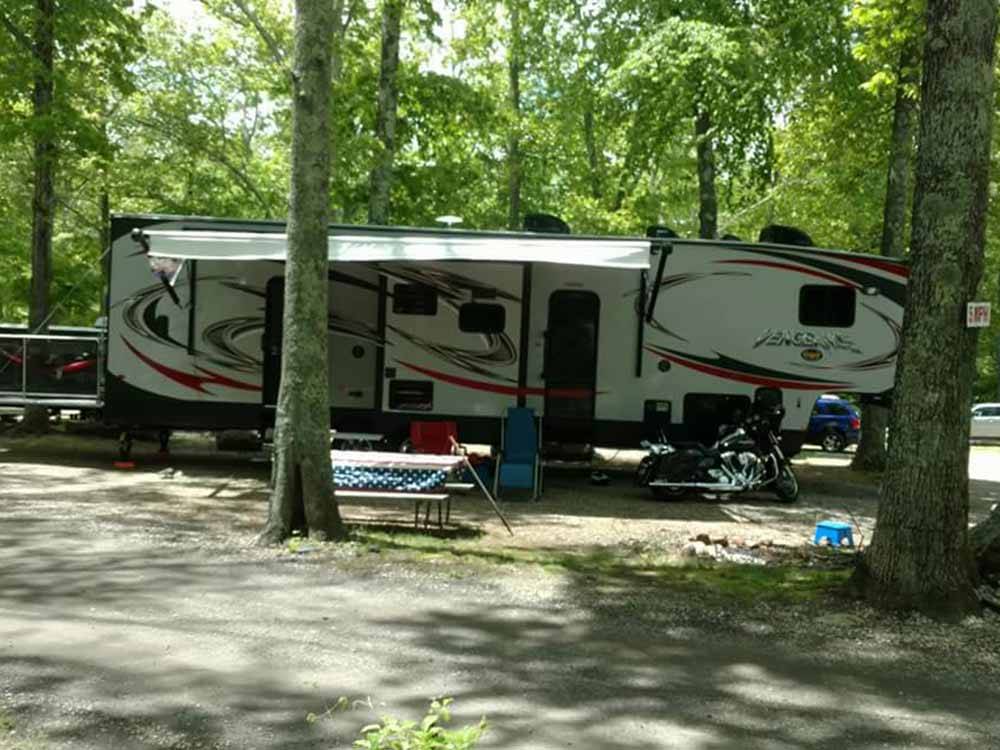 A fifth wheel trailer under some trees at SALEM FARMS CAMPGROUND