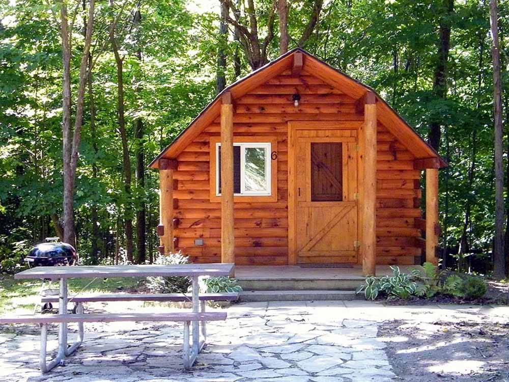 Guest cabin with picnic bench at CAMPERS COVE CAMPGROUND