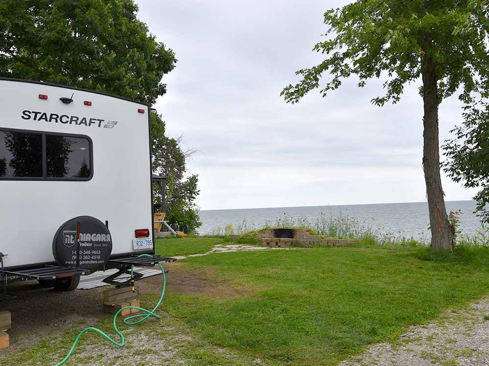 Trailer parked at campsite, overlooking water at CAMPERS COVE CAMPGROUND