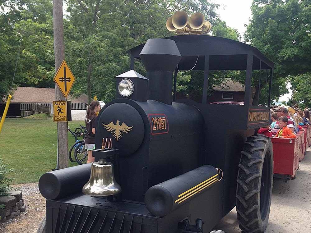 A tractor that looks like a train pulling people at CAMPERS COVE CAMPGROUND