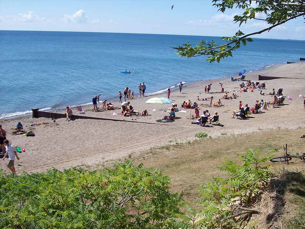 People on the beach nearby at CAMPERS COVE CAMPGROUND