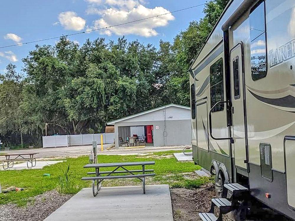 Parked RV and picnic bench at HAPPY TRAVELER RV RESORT