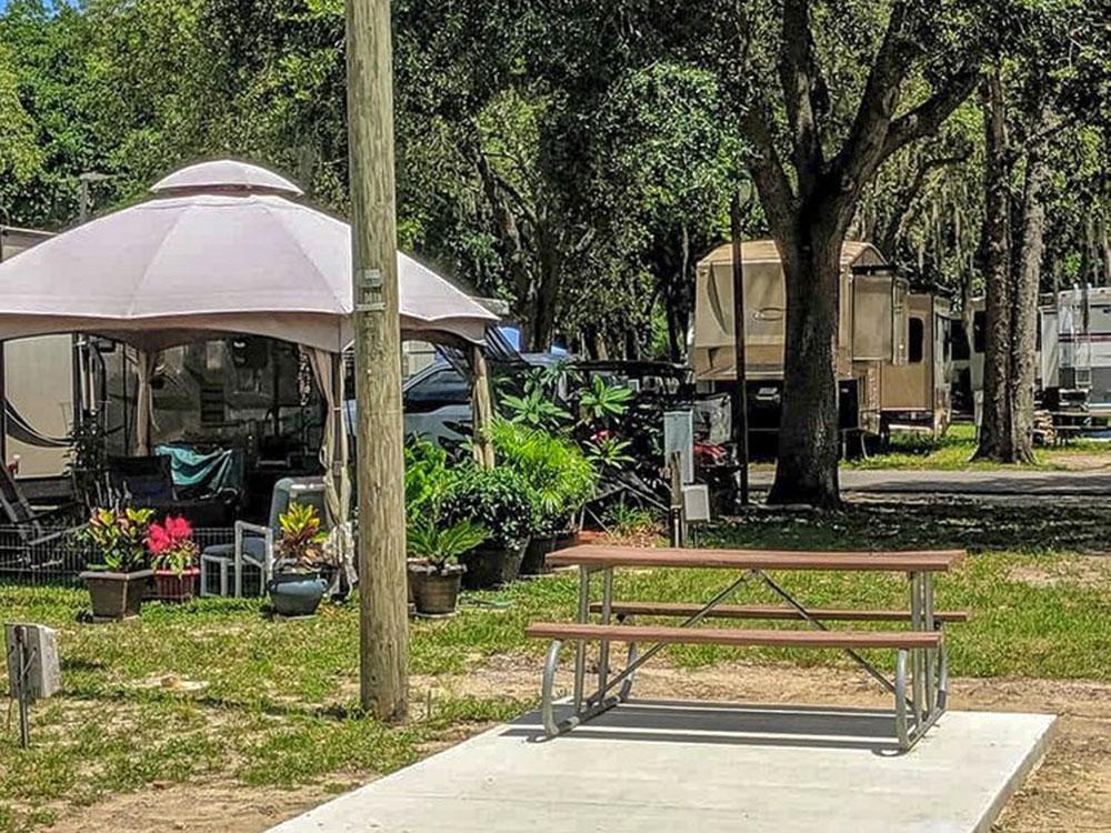 Gazebo, picnic bench and RVs at HAPPY TRAVELER RV RESORT