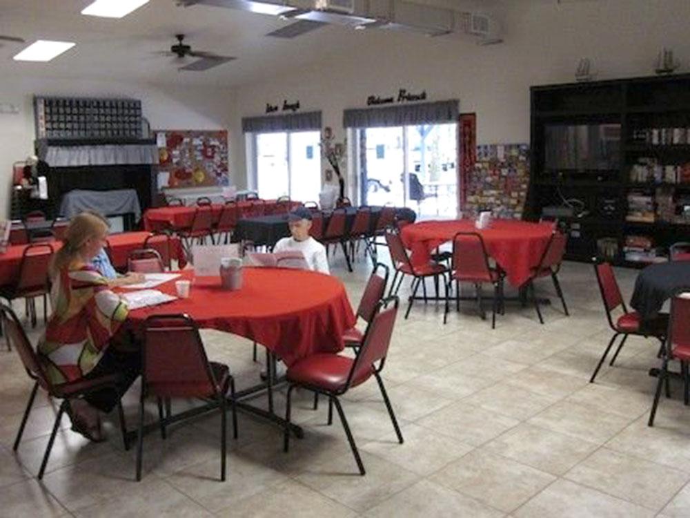 Tables and chairs in the rec room at HAPPY TRAVELER RV RESORT