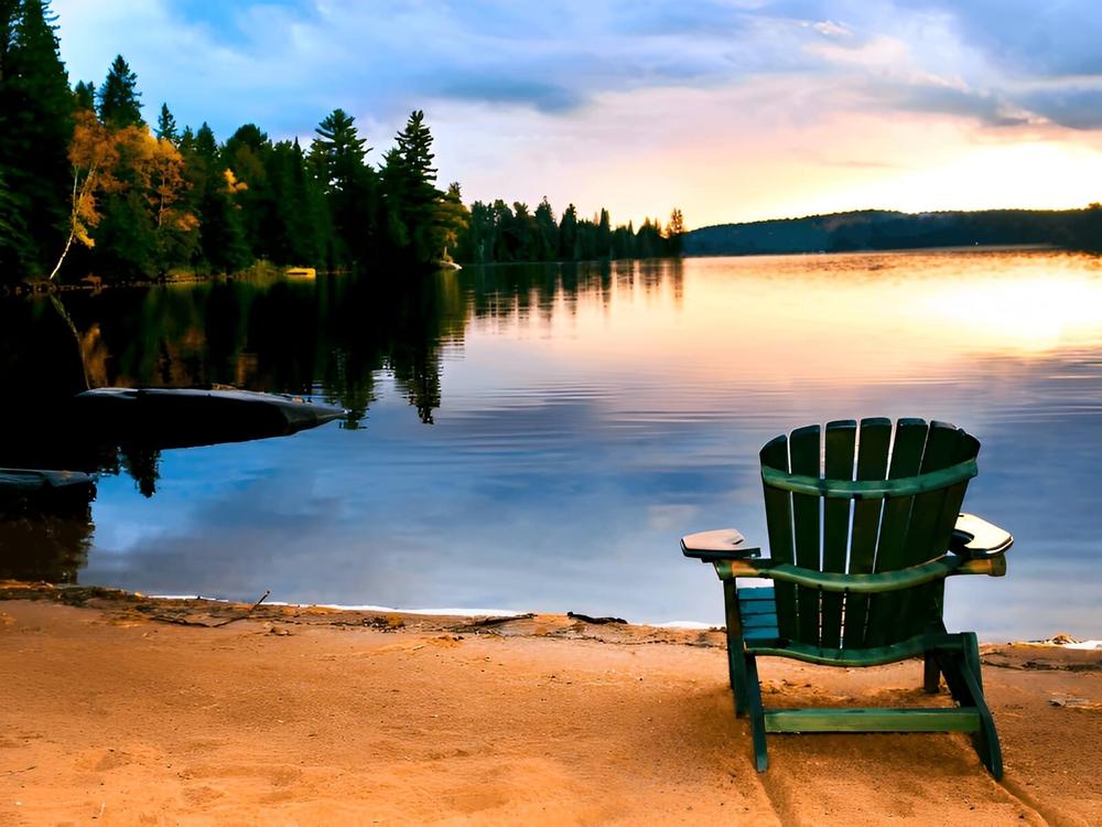 A chair near the water at sunset
