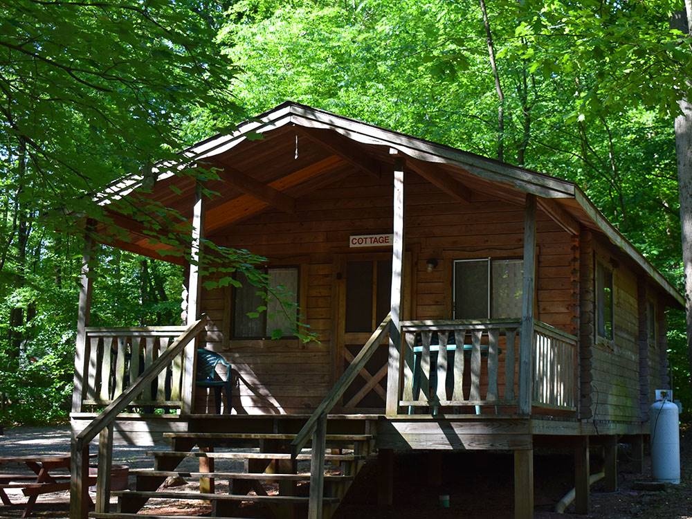 A wooden cottage surrounded by trees at PINCH POND FAMILY CAMPGROUND