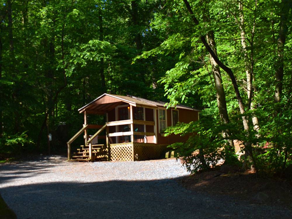 A wooden cabin with a deck at PINCH POND FAMILY CAMPGROUND