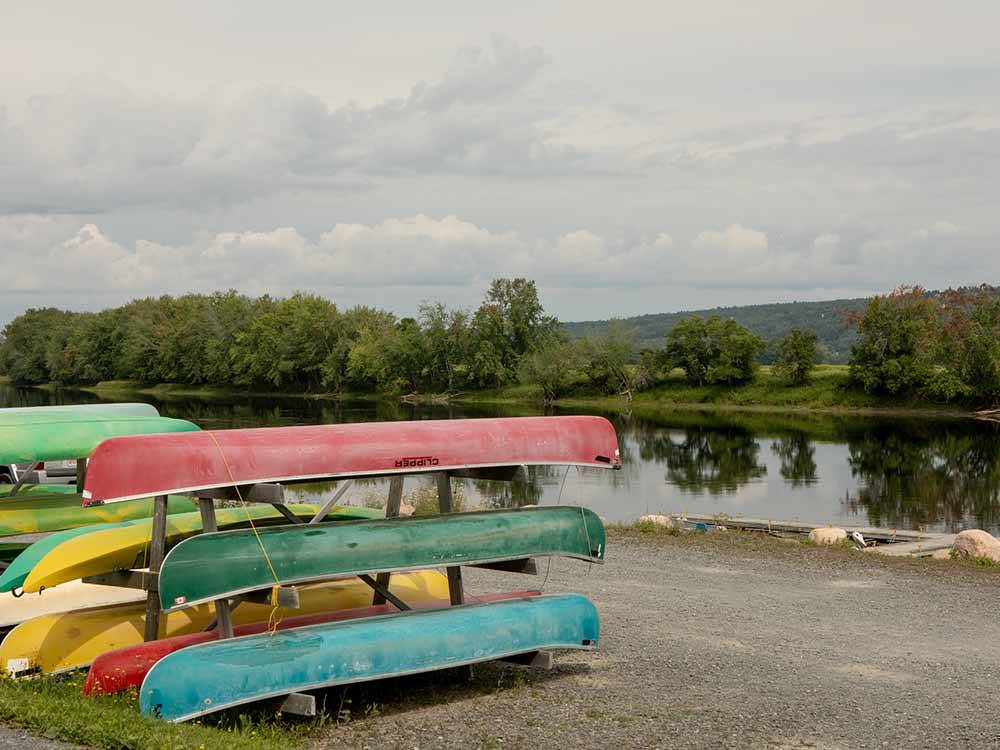 A stack of canoes along the water at HARTT ISLAND RV RESORT & WATERPARK