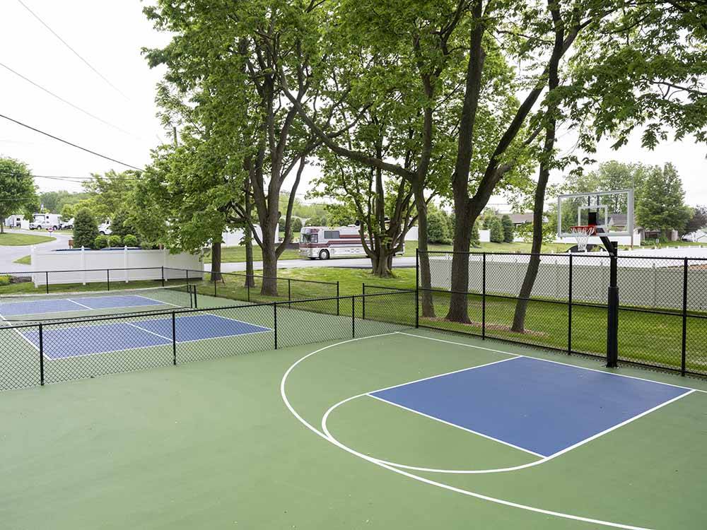 Basketball court with green surface next to a pickleball court at COUNTRY ACRES CAMPGROUND