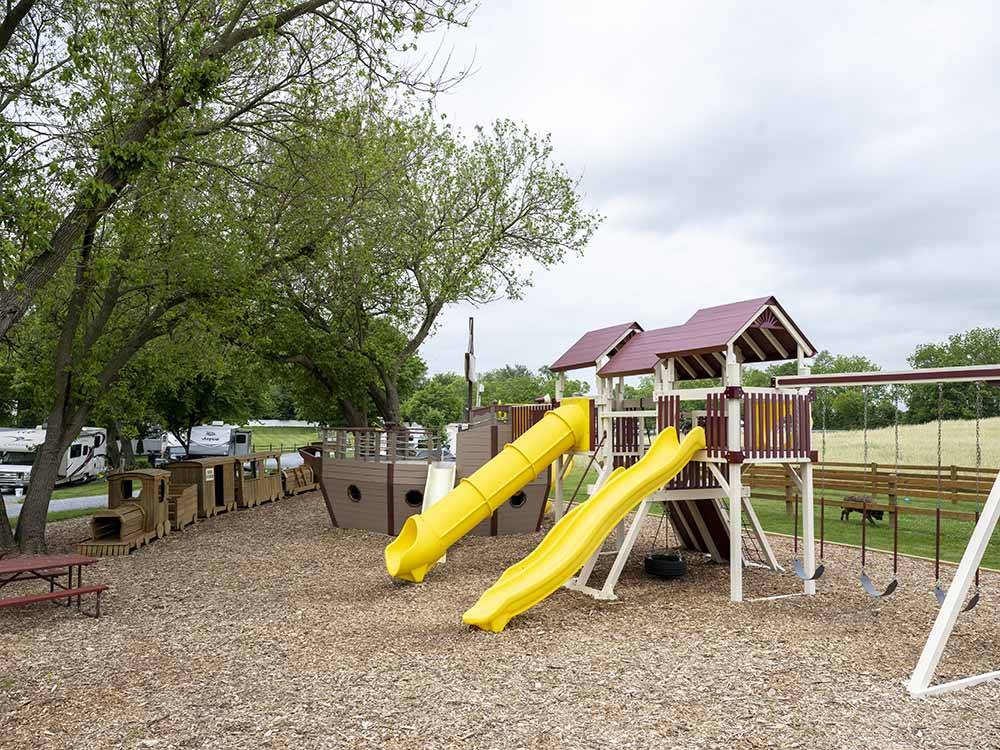 Play structures with bright yellow slides at COUNTRY ACRES CAMPGROUND