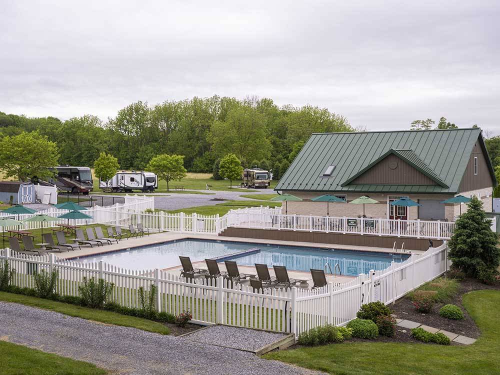 Rectangular pool surrounded by white picket fence at COUNTRY ACRES CAMPGROUND