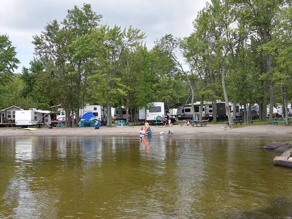 Travel trailers in a row at water view sites at GLENROCK COTTAGES & TRAILER PARK