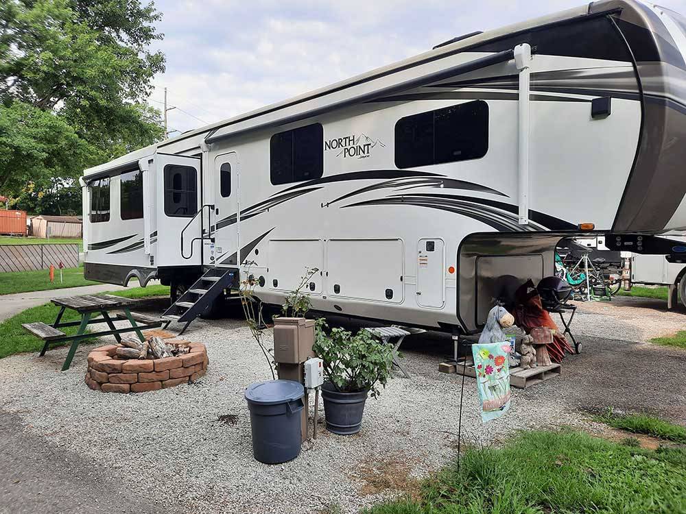 A fifth wheel trailer parked in a gravel site at LOUISVILLE NORTH CAMPGROUND