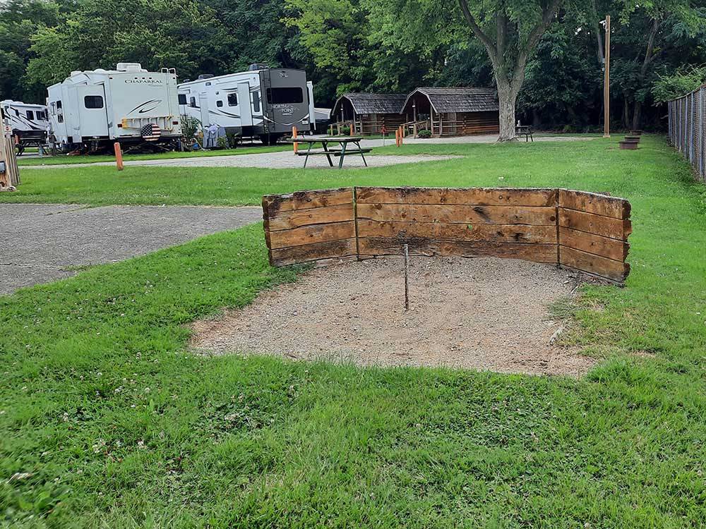 The horseshoe pit next to picnic benches and fire pits at LOUISVILLE NORTH CAMPGROUND