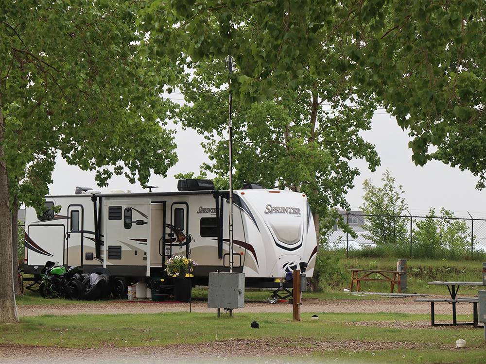A motorhome in a campsite at GLOWING EMBERS RV PARK & TRAVEL CENTRE