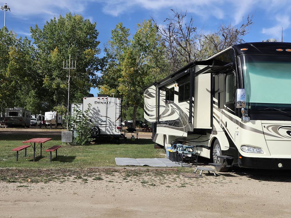 Campsite with picnic table and motorhome at GLOWING EMBERS RV PARK & TRAVEL CENTRE
