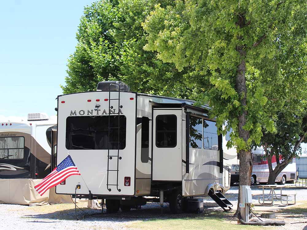 A fifth wheel trailer under a tree at COUNCIL ROAD RV PARK