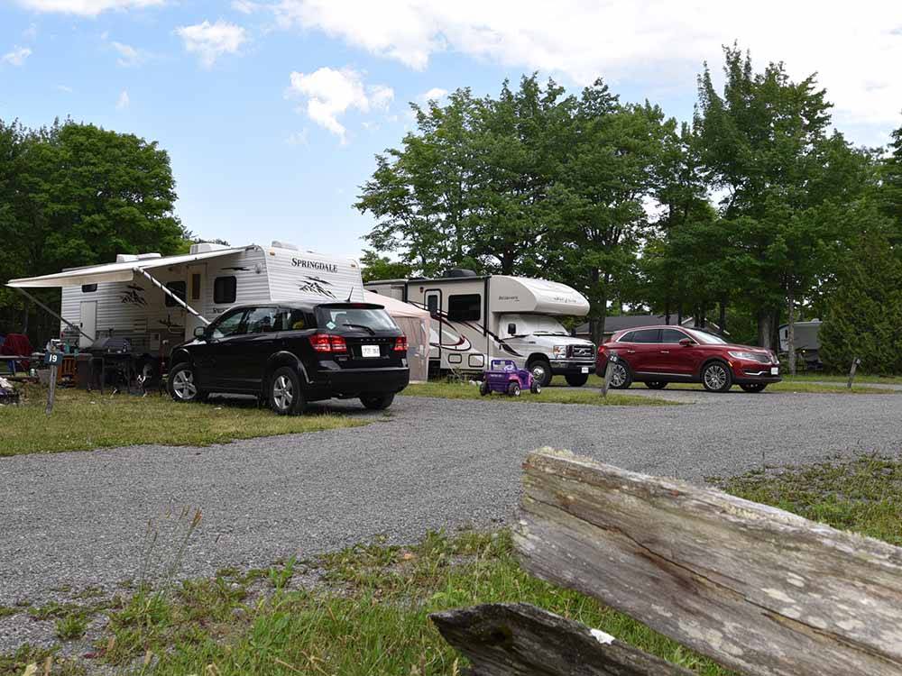 A row of RVs in gravel RV sites at GLENVIEW COTTAGES & RV PARK