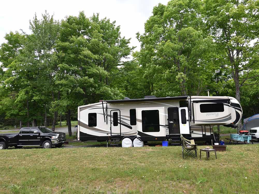 A fifth wheel trailer in a campsite at GLENVIEW COTTAGES & RV PARK
