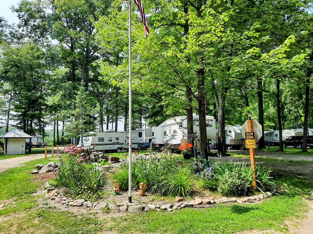 An area with flowers and the American flag at HIDDEN HILL FAMILY CAMPGROUND