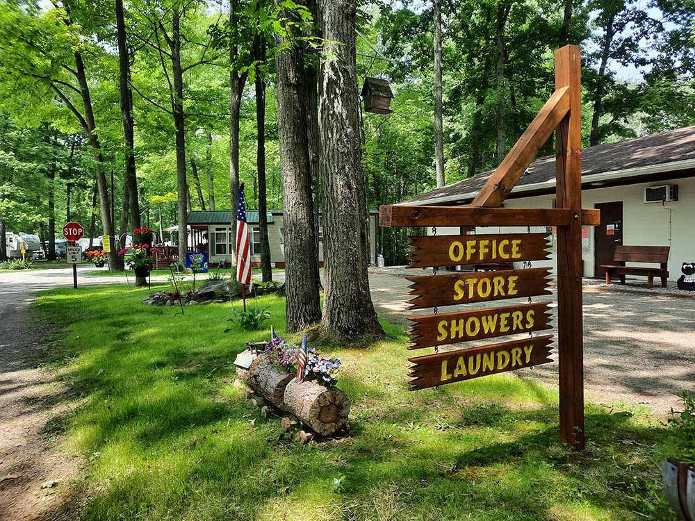 A wooden directional sign at HIDDEN HILL FAMILY CAMPGROUND