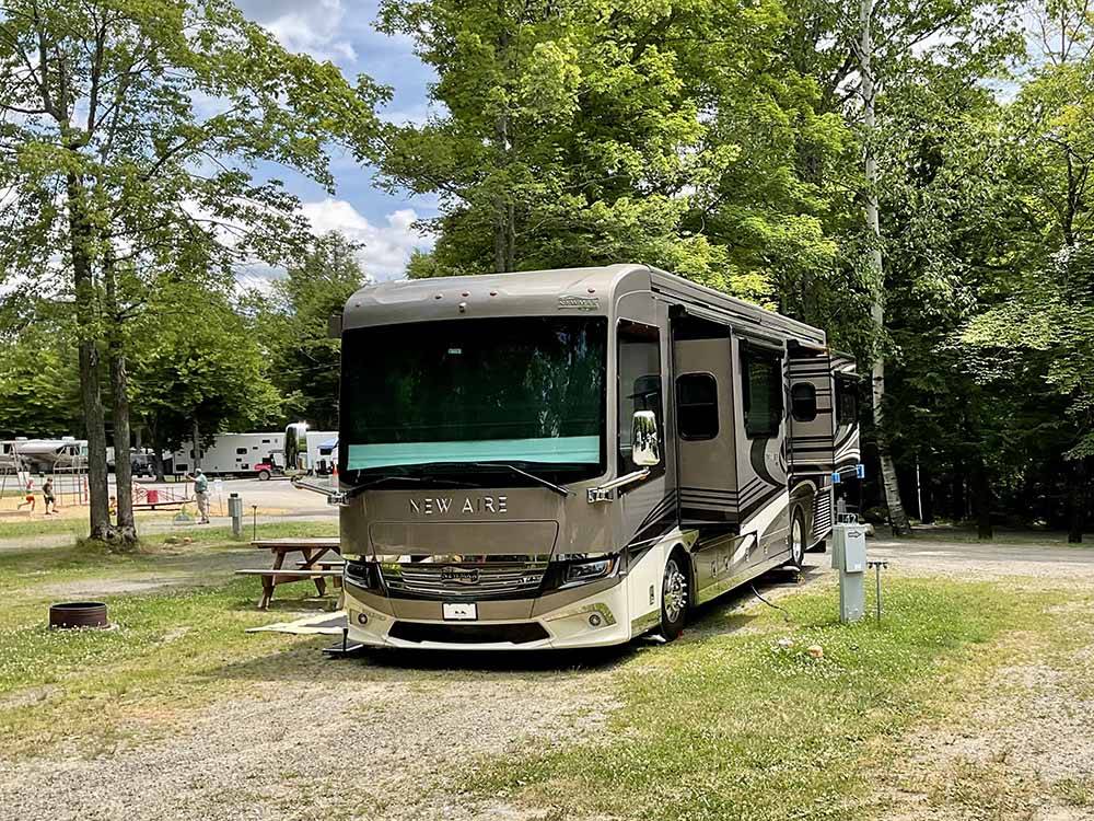 A motorhome in a gravel RV site at KATAHDIN SHADOWS CAMPGROUND & CABINS