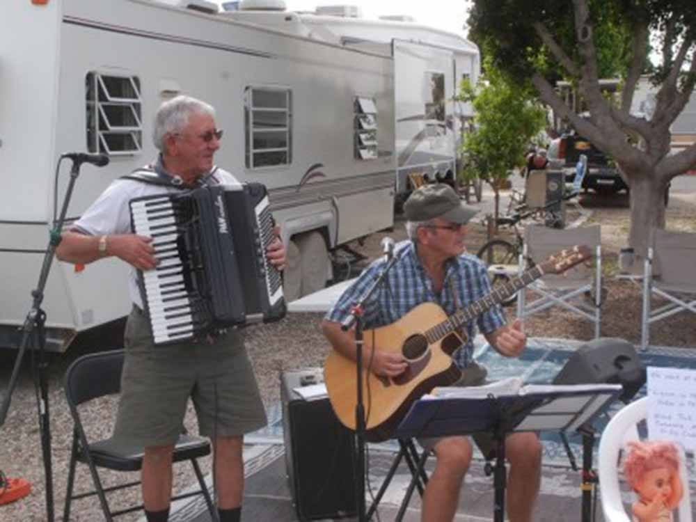 A couple of gentlemen playing musical instruments at SHANGRI-LA RV RESORT