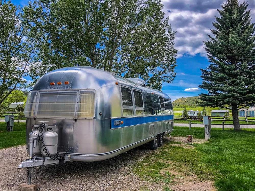 An Airstream trailer parked in a gravel site at SWAN VALLEY RV PARK