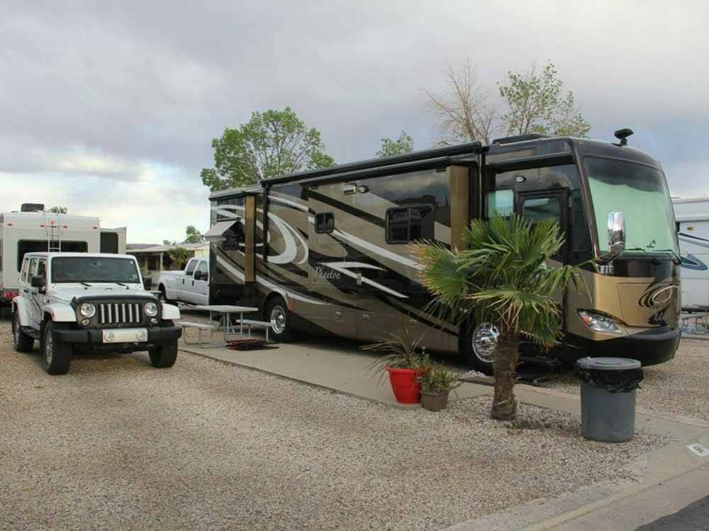 A Class A motorhome parked in a gravel spot at MCARTHUR'S TEMPLE VIEW RV RESORT