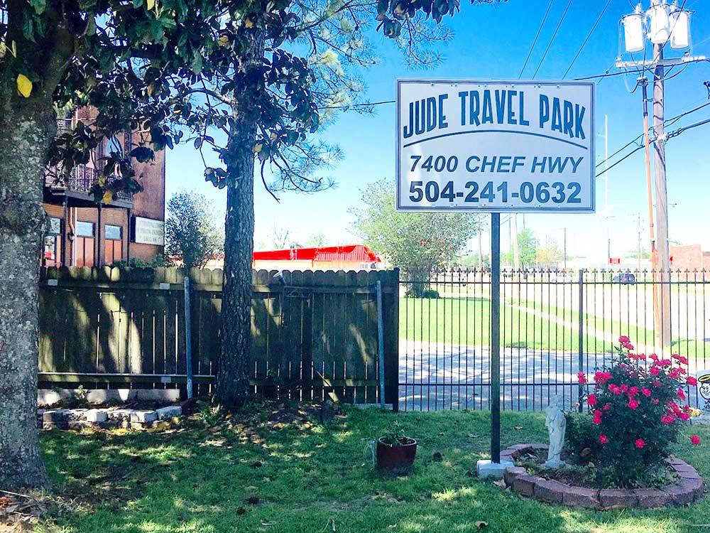Entrance sign next to a flower planter at JUDE TRAVEL PARK OF NEW ORLEANS