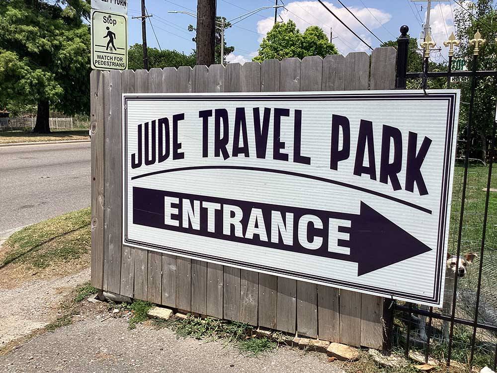 The entrance sign on a wood fence at JUDE TRAVEL PARK OF NEW ORLEANS