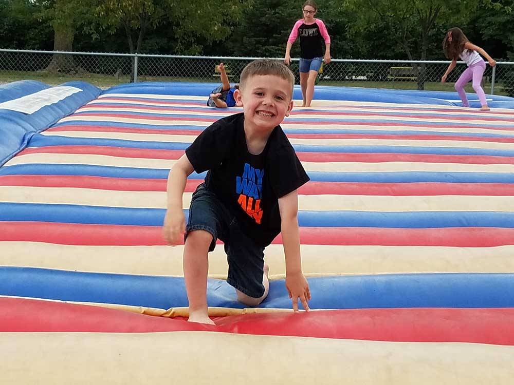 A boy having fun on the jumping pillow at CAMELOT CAMPGROUND QUAD CITIES