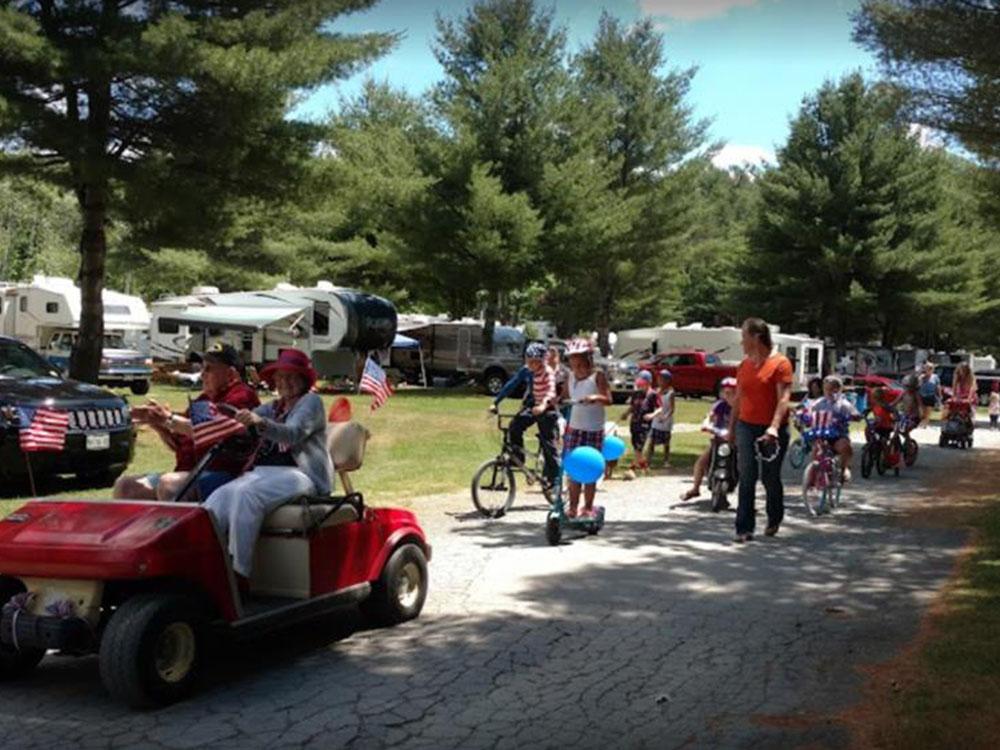A couple riding on a red golf cart at TWO RIVERS CAMPGROUND