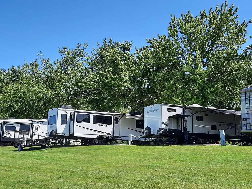 A row of trailers next to the grass at RIVERSIDE RV PARK & RESORT
