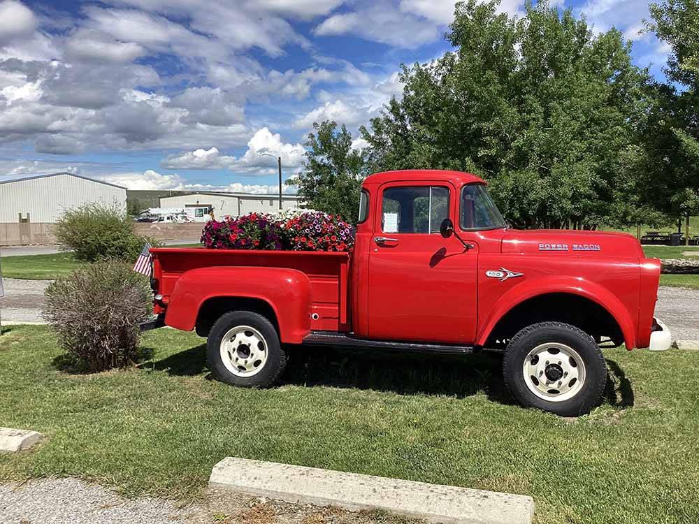 An old red Power Wagon truck with flowers in the bed at INDIAN CREEK RV PARK & CAMPGROUND