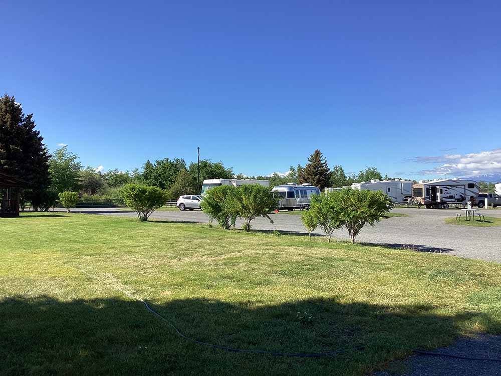 A large grassy area with bushes at INDIAN CREEK RV PARK & CAMPGROUND