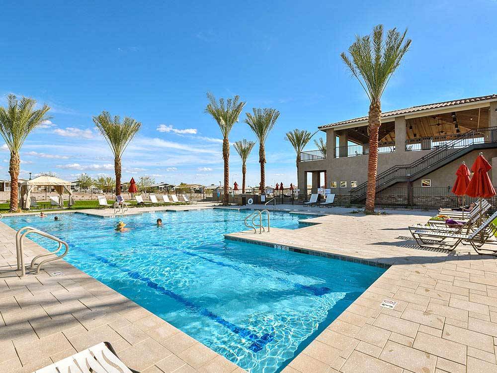 Swimming pool with palm trees and red umbrellas at VIEWPOINT RV & GOLF RESORT