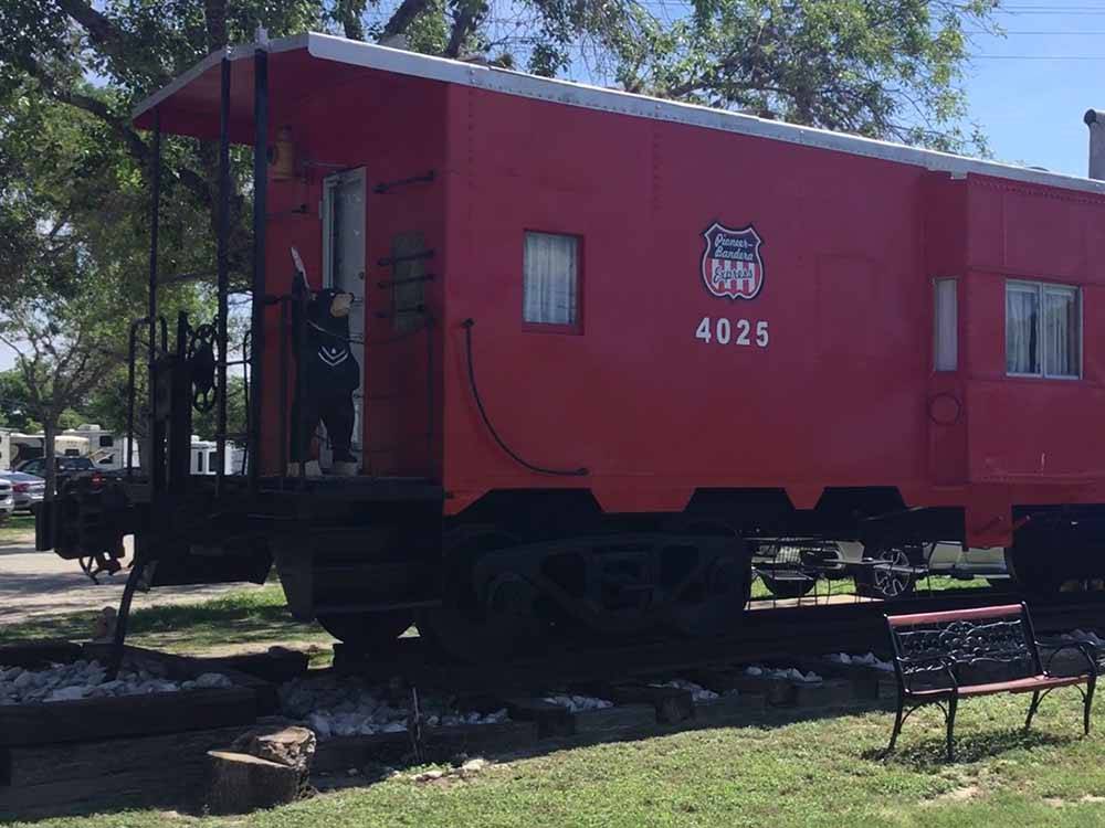 Bear statue standing on the red caboose at BANDERA PIONEER RV RIVER RESORT