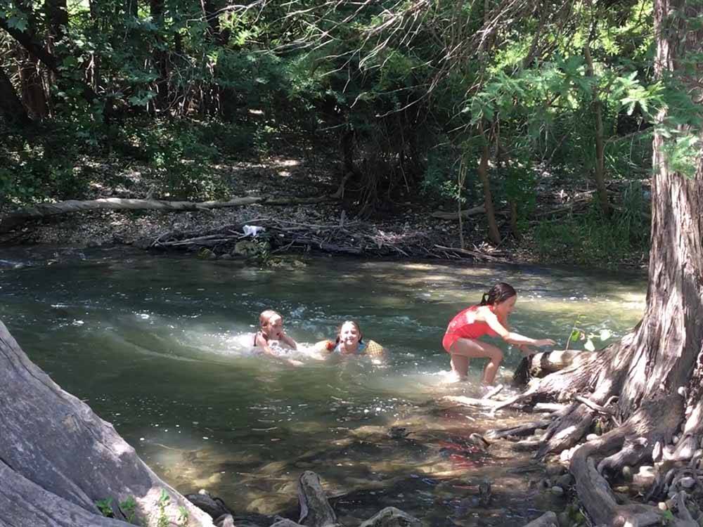 Kids playing in the river at BANDERA PIONEER RV RIVER RESORT