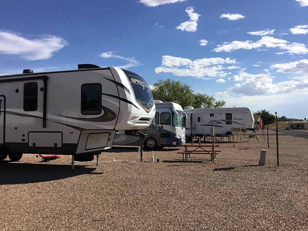 Fifth-wheels and motorhome under blue sky at OK RV PARK