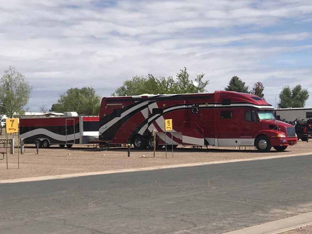 Big diesel motorhome with trailer in a pull-through site at OK RV PARK