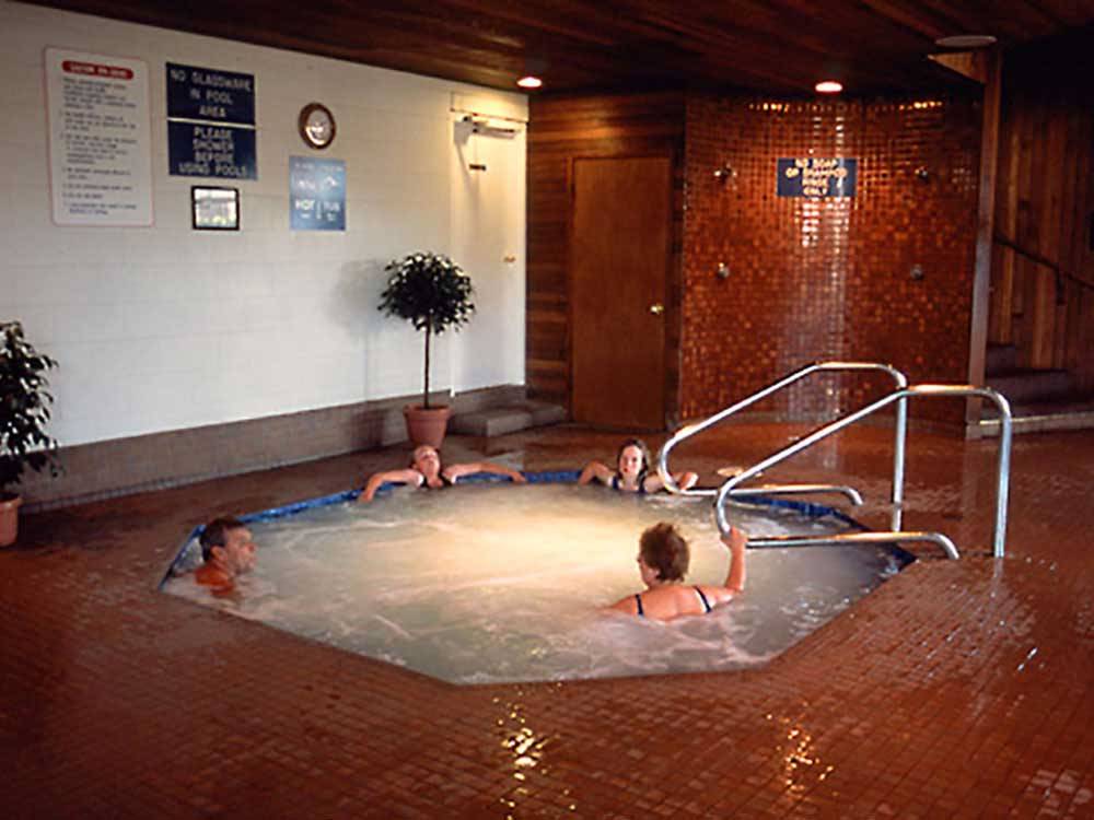 People in the indoor hot tub with brown tile flooring at BURNABY CARIBOO RV PARK