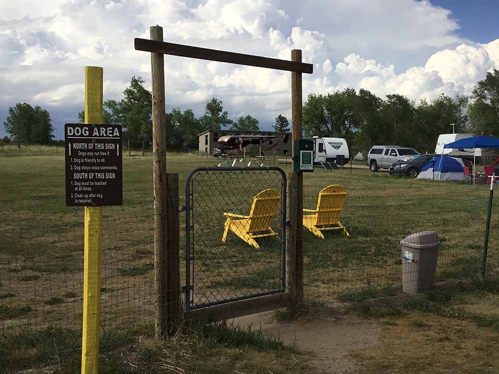 The dog park with a couple of yellow chairs at FALCON MEADOW RV CAMPGROUND
