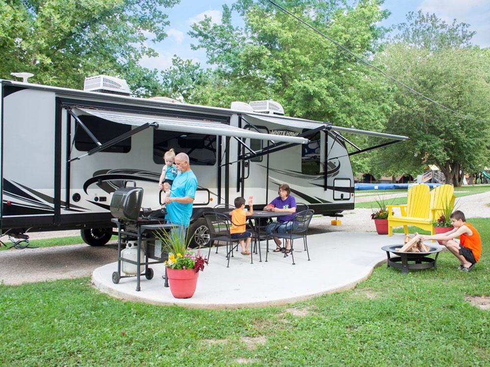 Parked RV and family sitting outside at RENFRO VALLEY KOA HOLIDAY