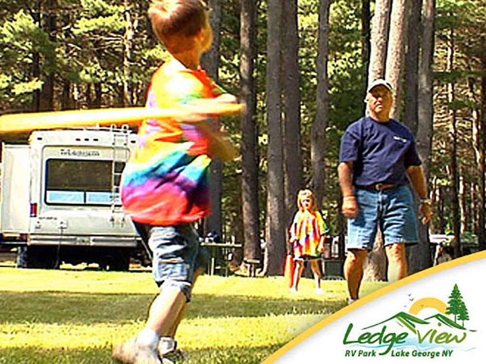 Father playing baseball with children at LEDGEVIEW RV PARK