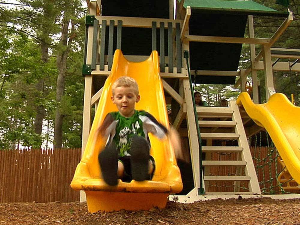 Boy sliding down slide at playground at LEDGEVIEW RV PARK